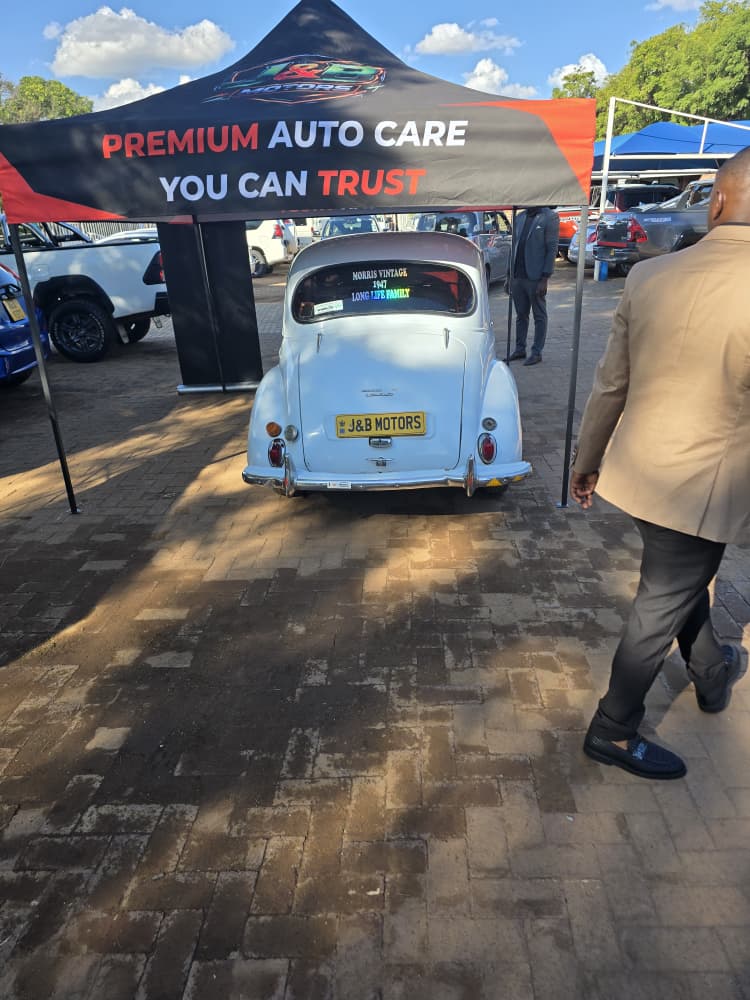 Rear plate view of the 1957 Morris Minor under the J&B Motors marquee