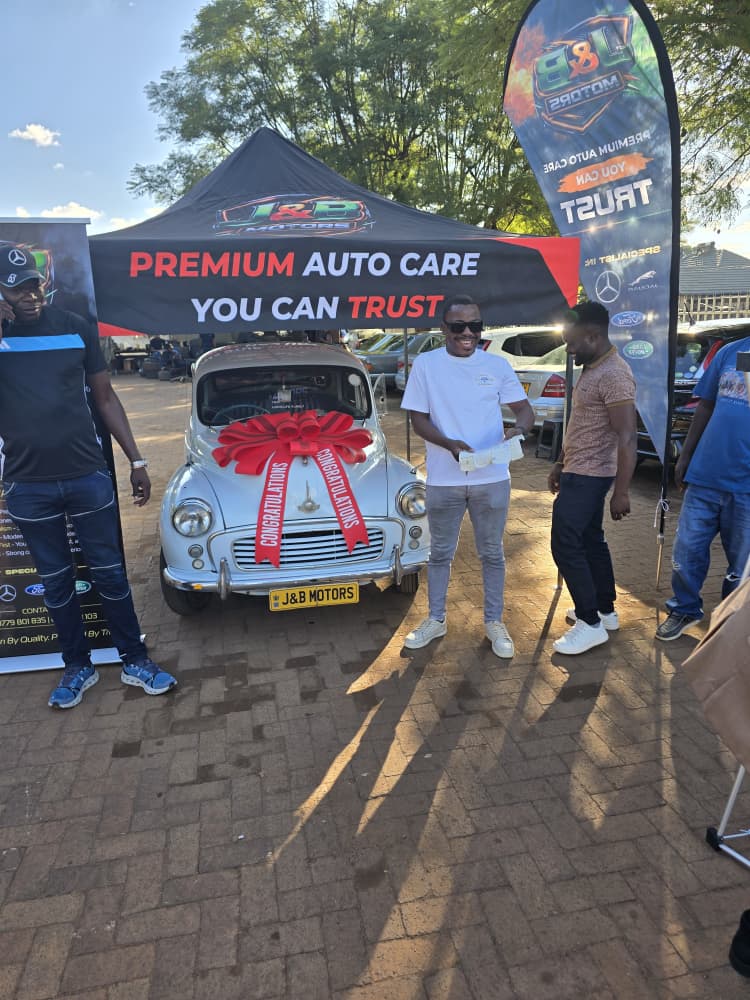 Mr Mawena receiving the keys, reading the card from the J&B family
